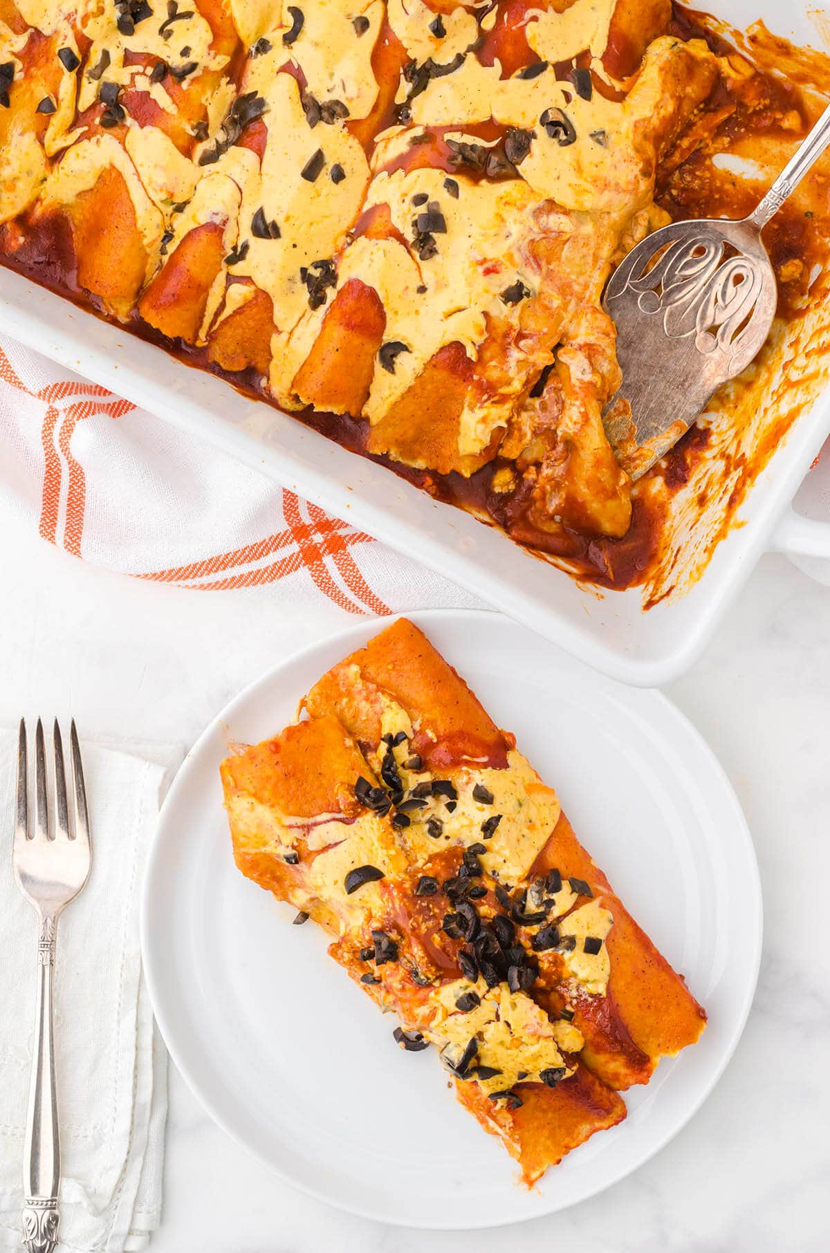 Enchiladas in casserole dish and two dished up onto plate. 