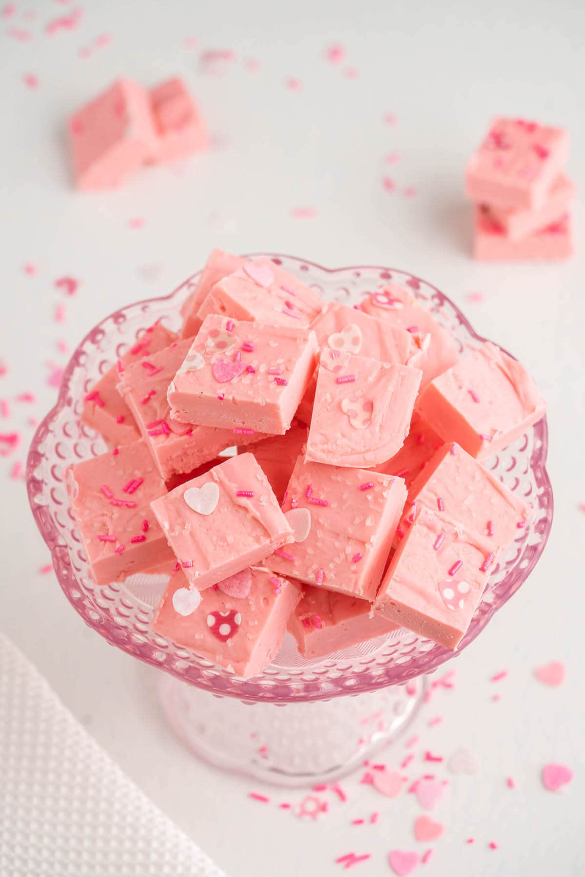 Strawberry fudge decorated with sprinkles in pink bowl.