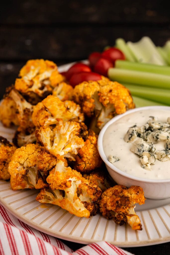 Roasted Buffalo Cauliflower on platter with celery and blue cheese dip. 