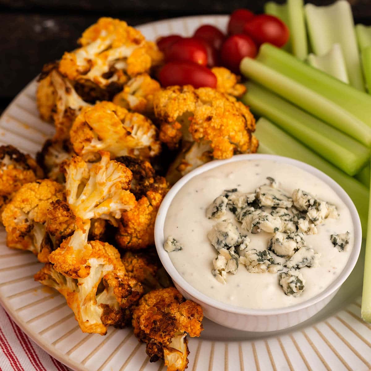 Air Fryer Buffalo Cauliflower appetizer on platter with celery and blue cheese dip.