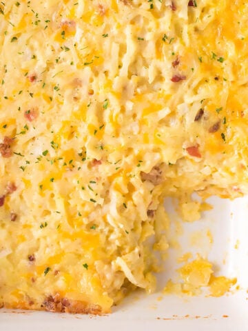 Cheesy Hashbrown Casserole in baking dish with one portion removed.
