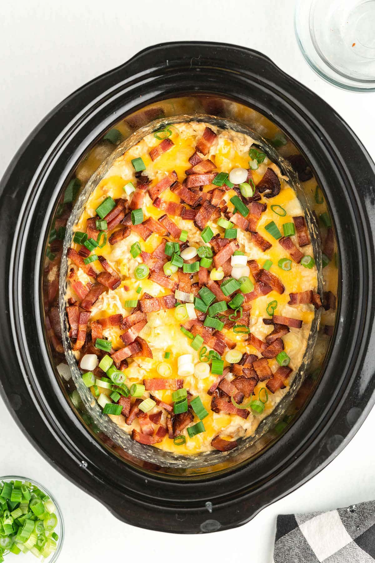 Crack chicken in crockpot topped with cheese, onions and bacon.