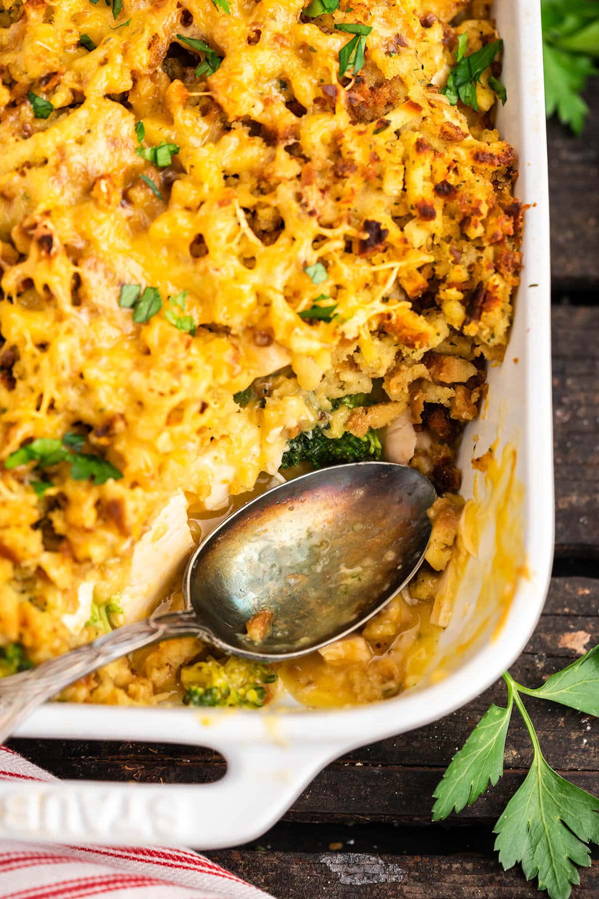 Baking dish filled with chicken stuffing casserole, with serving spoon.