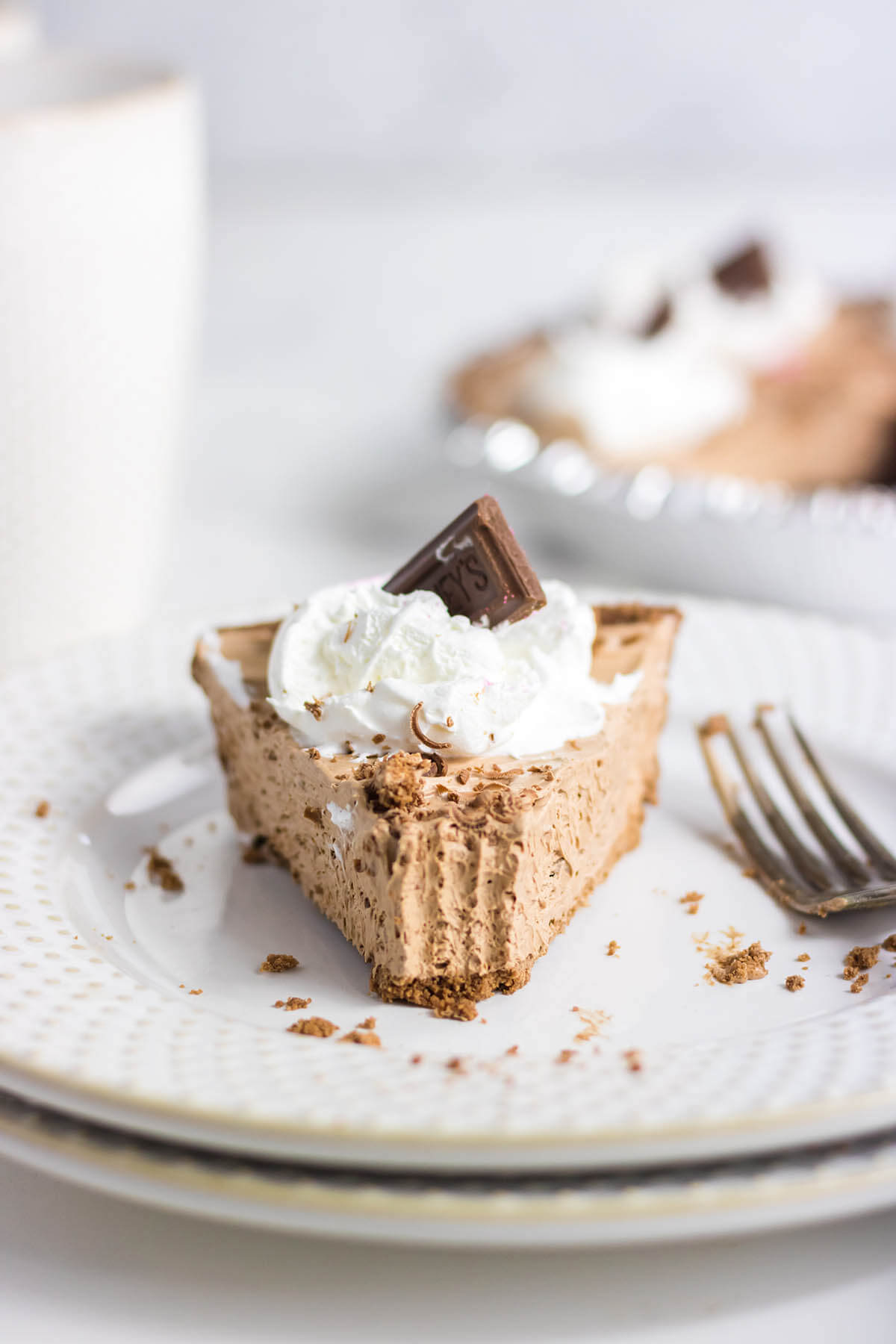 A slice of Chocolate Hershey Pie on plate with a fork. 