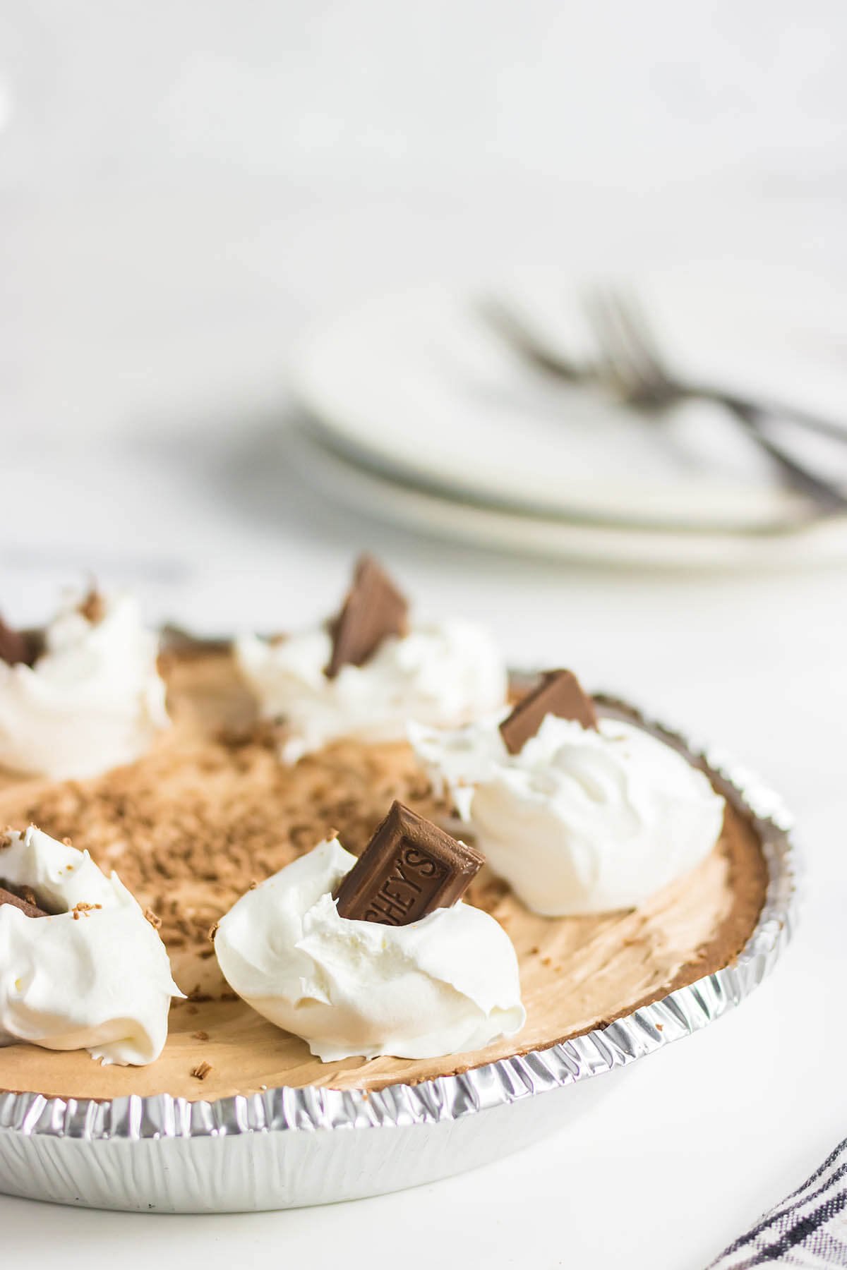 No bake Hershey chocolate pie topped with dollops of cool whip and chocolate squares. 