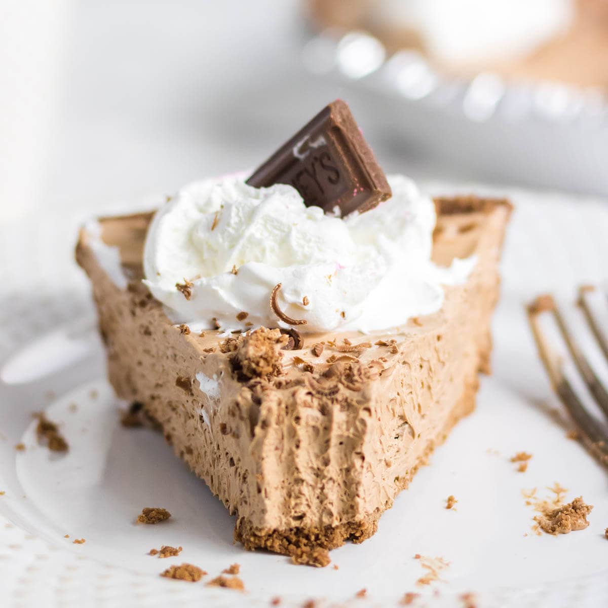 Slice of no bake chocolate Hershey Pie on plate with fork.