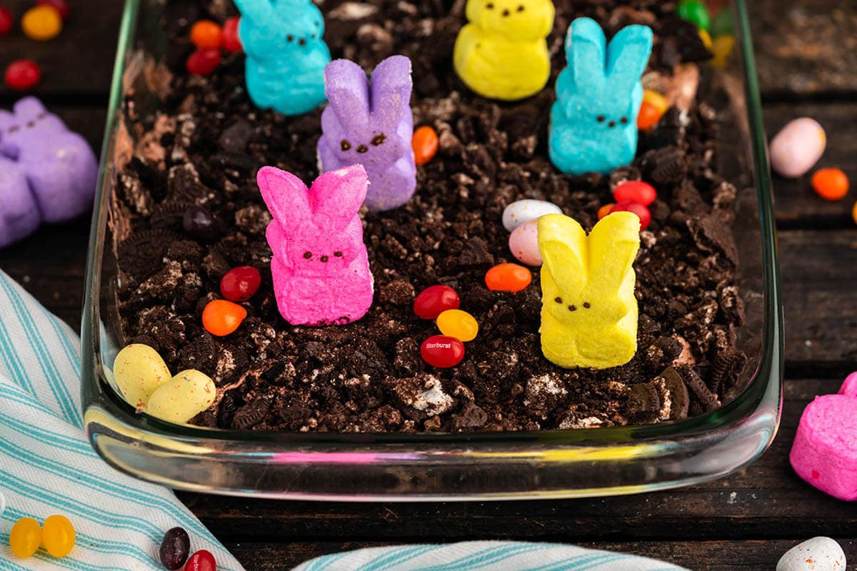Peeps Easter Dirt Cake topped with bunny peeps and candy eggs. 