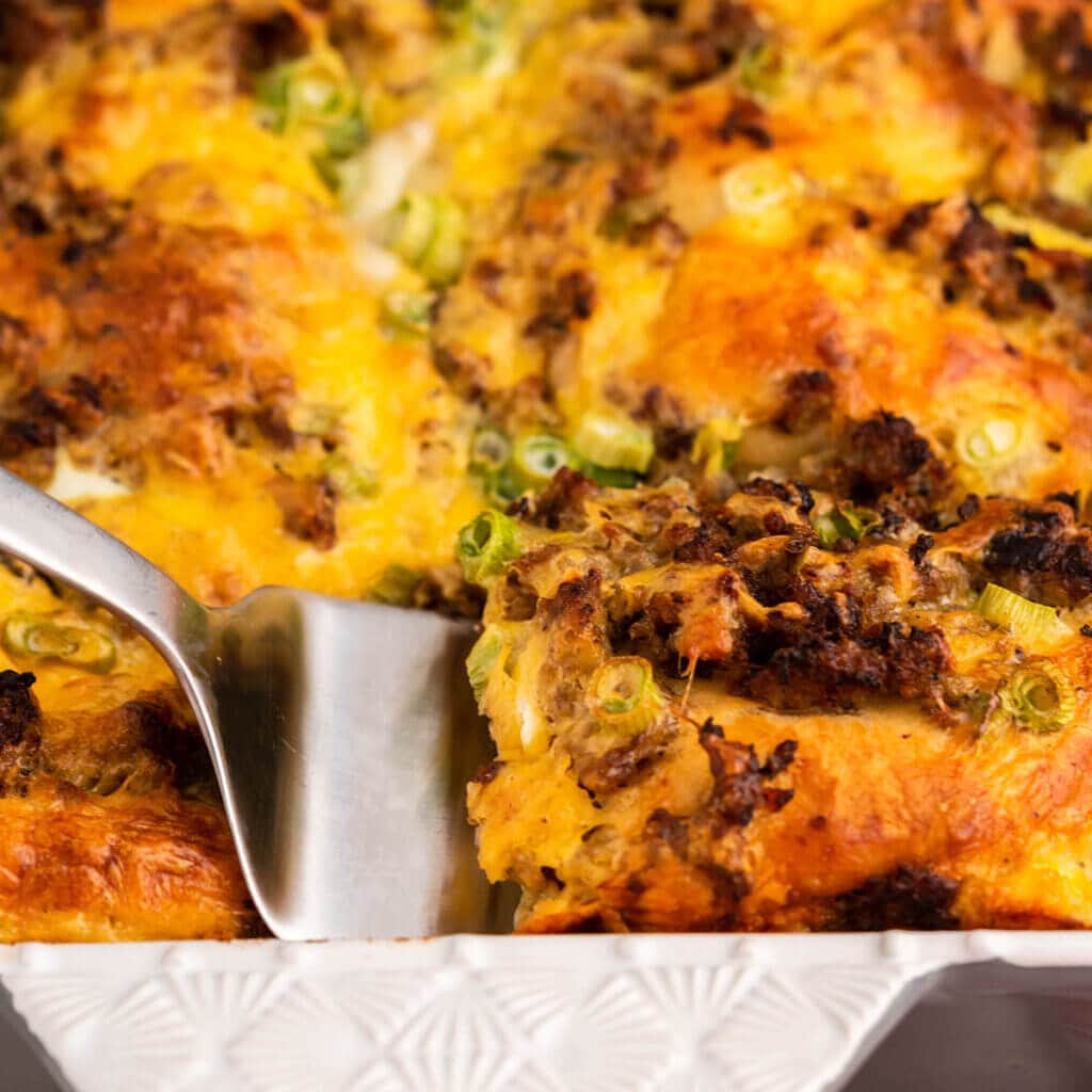 Sausage Breakfast Casserole in dish with serving spoon.