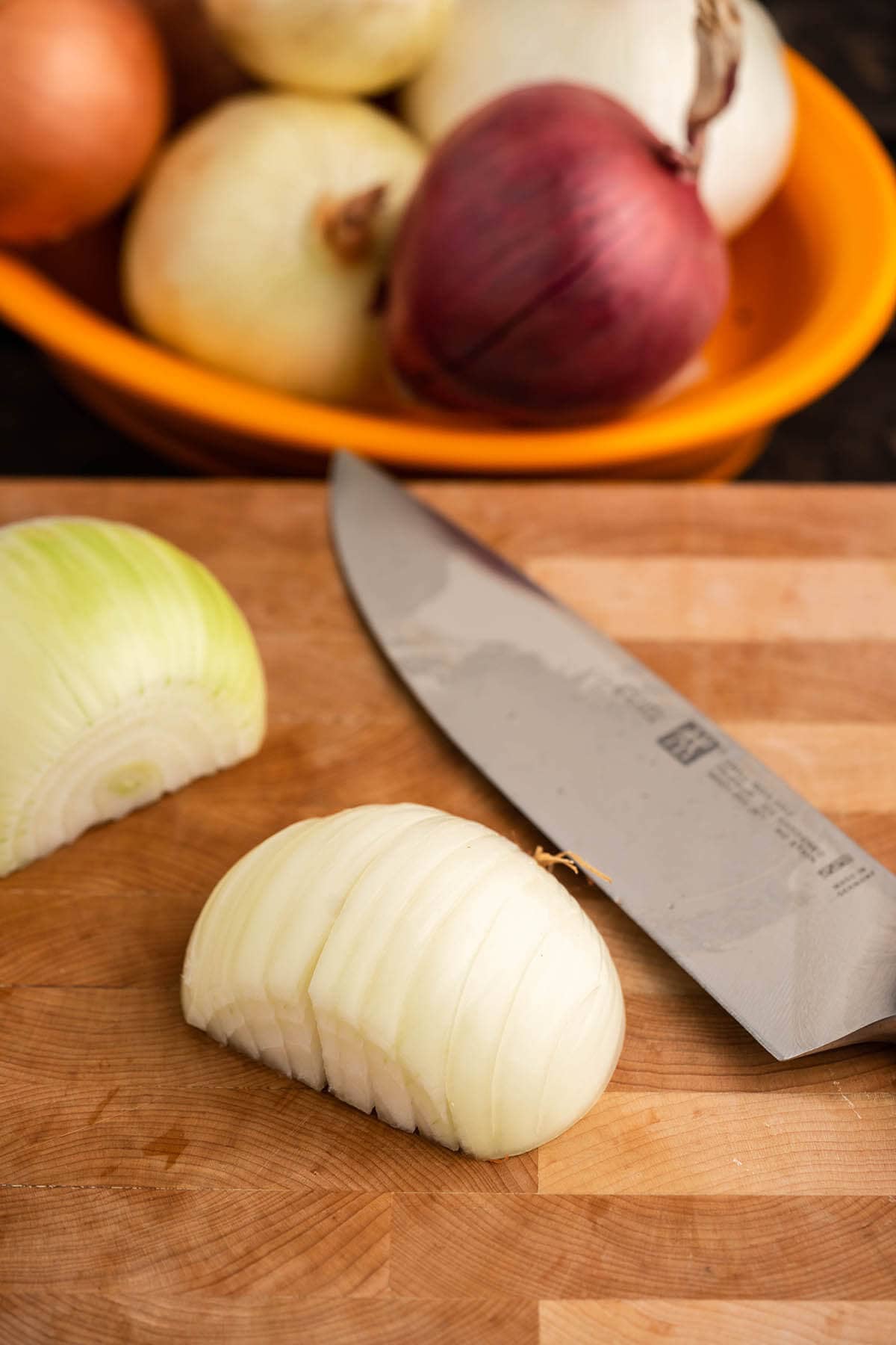 Peeled onion on cutting board with knife.