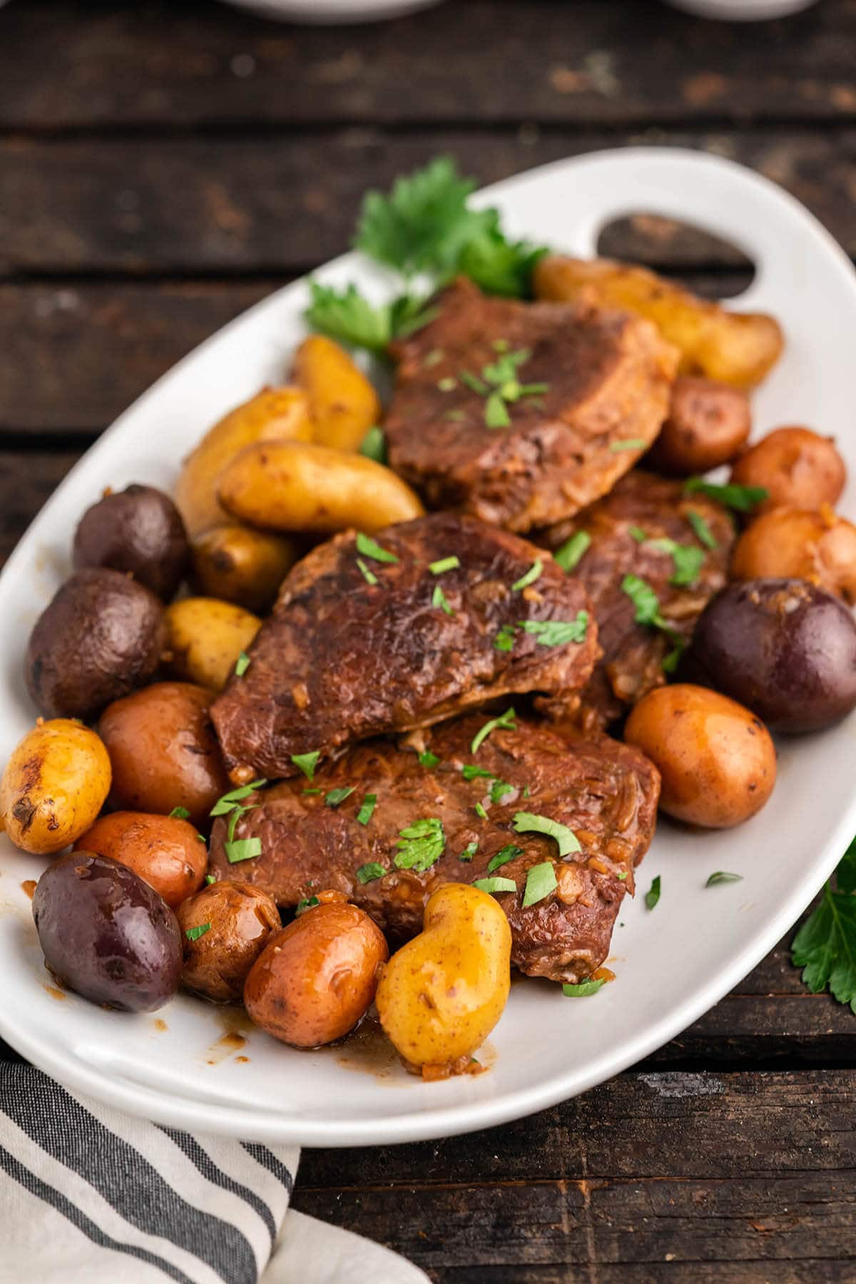 Beef and potatoes on platter with fingerling potatoes.