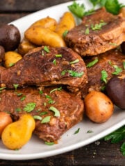 Crockpot Steak and Potatoes on serving platter garnished with parsley.