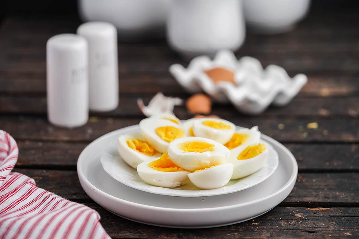 Air fryer boiled eggs on plate with egg shells. 