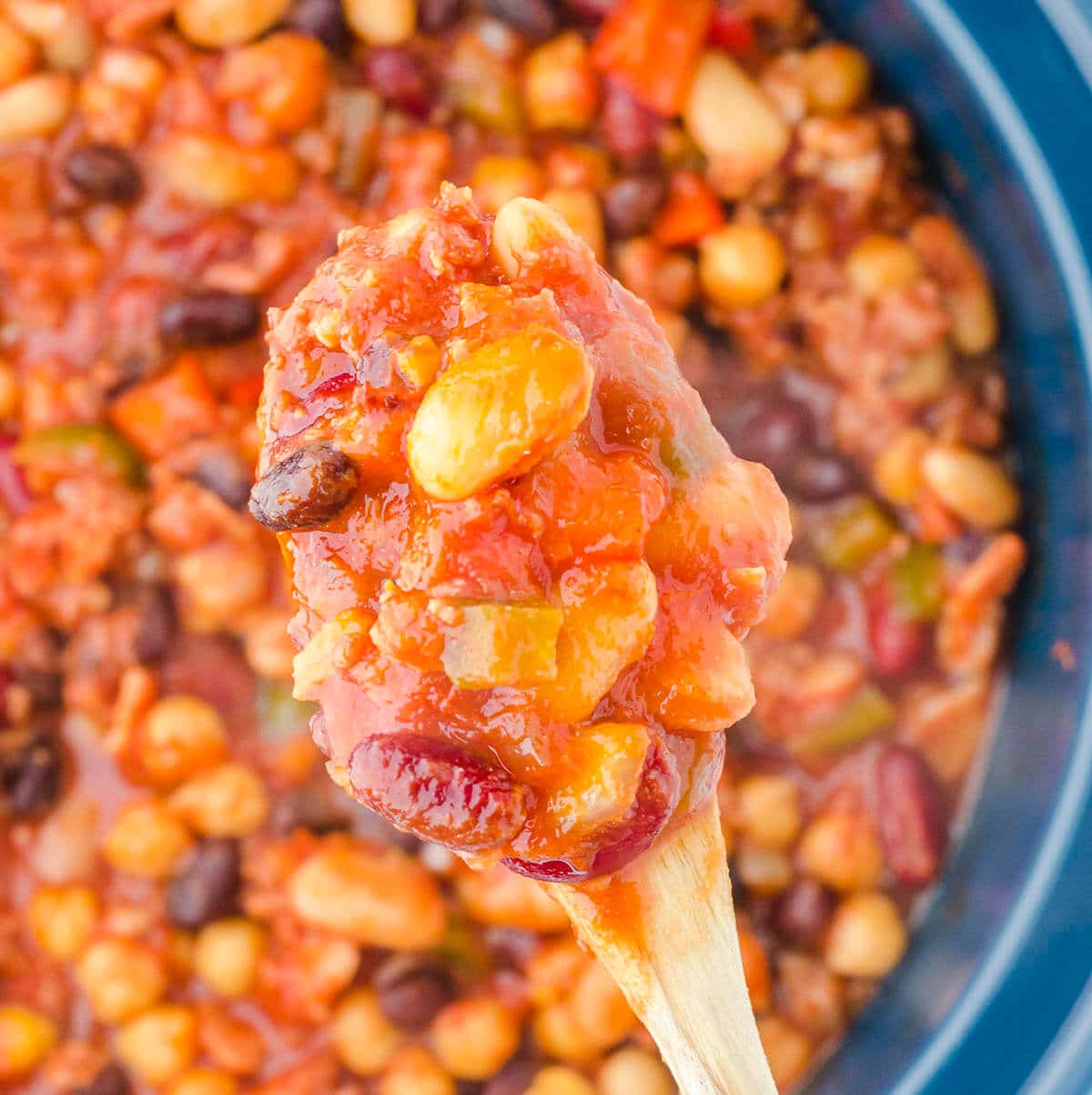 Crockpot baked beans with serving spoon.