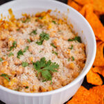 Mexican corn casserole recipe in baking dish with chips.