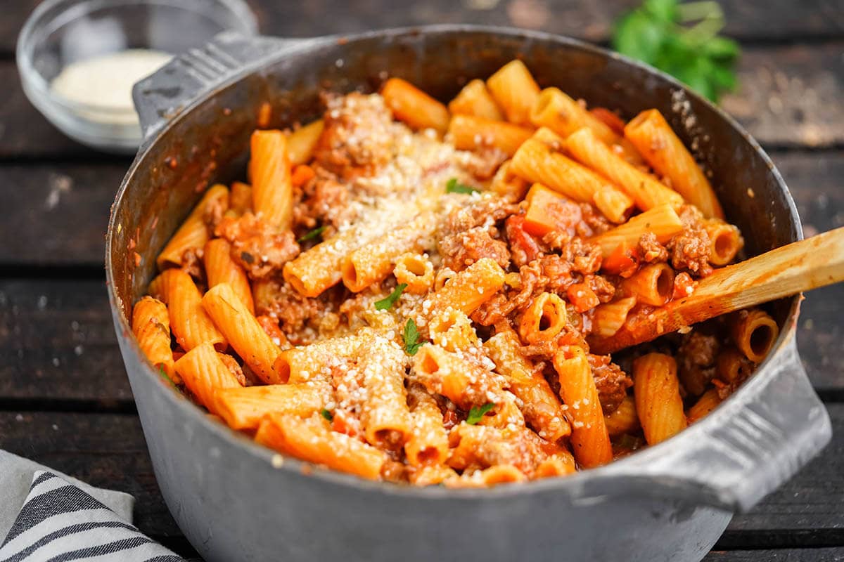 Rigatoni Bolognese in large pot, with wooden spoon. 