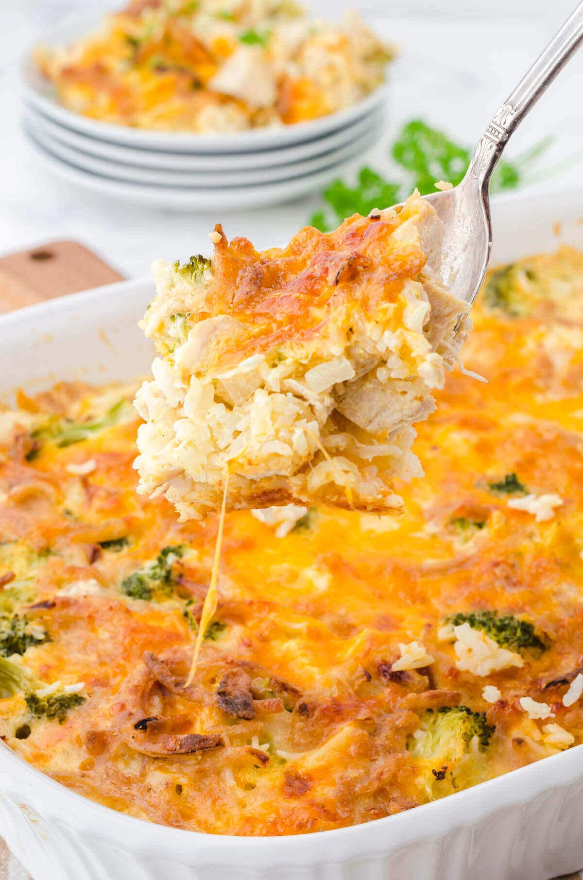 Cheesy chicken and rice casserole with serving spoon. 