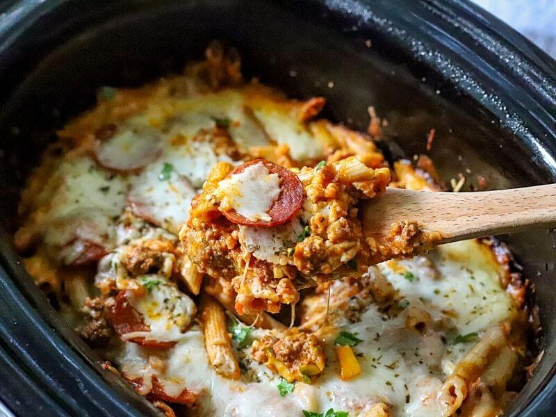 Crockpot pizza casserole with serving spoon. 