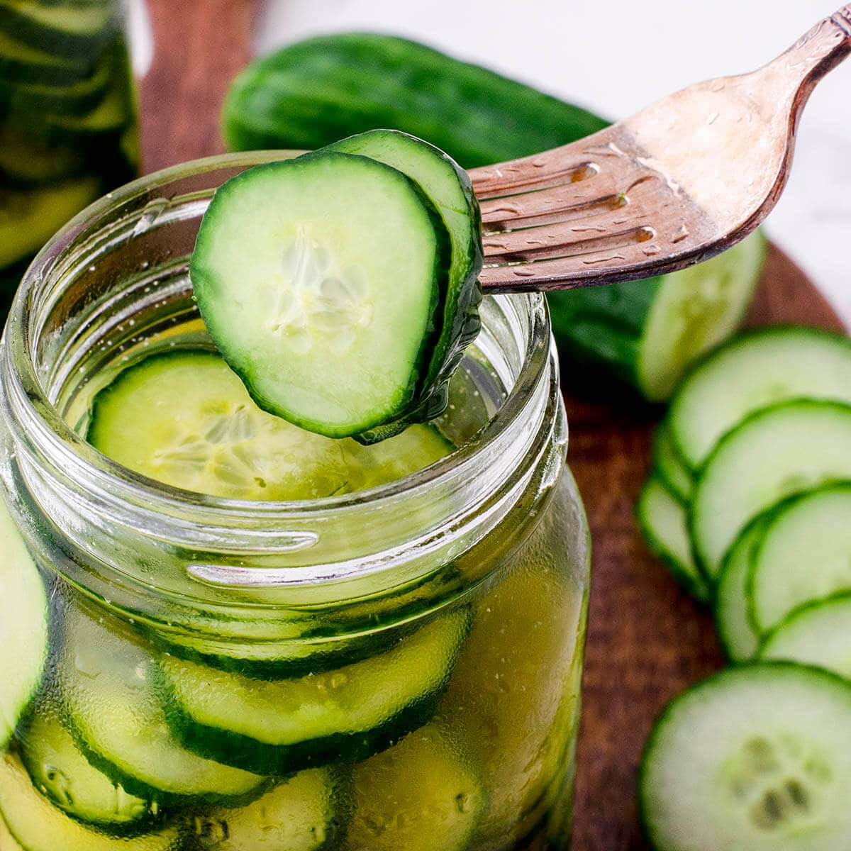 Pickles in jar with fork dishing one out.