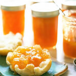 Pineapple Apricot Jam in jars and topping an English muffing.