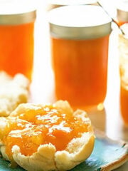 Pineapple Apricot Jam in jars and topping an English muffing.