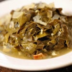 Cooked collard greens in white bowl.