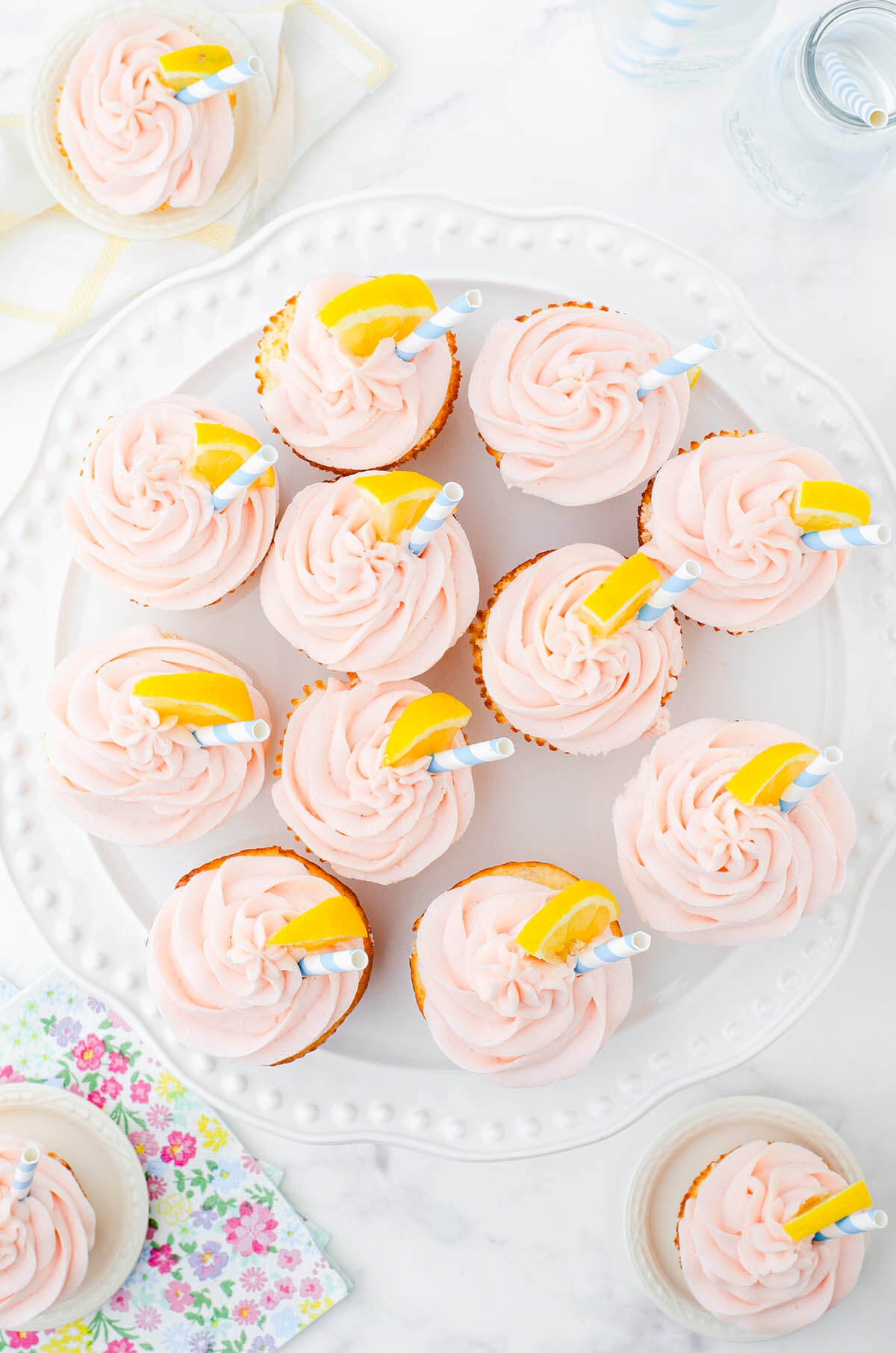 Pink lemonade cupcakes arranged around a cake platter.