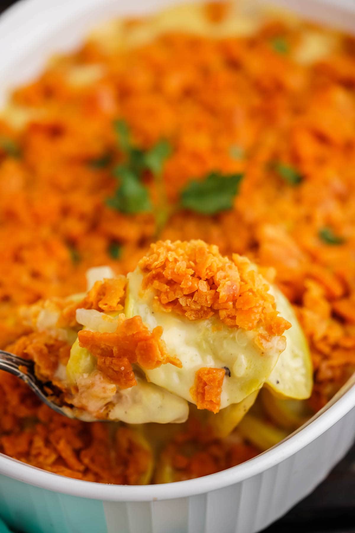 Old Fashioned Squash Casserole in baking dish with spoon.