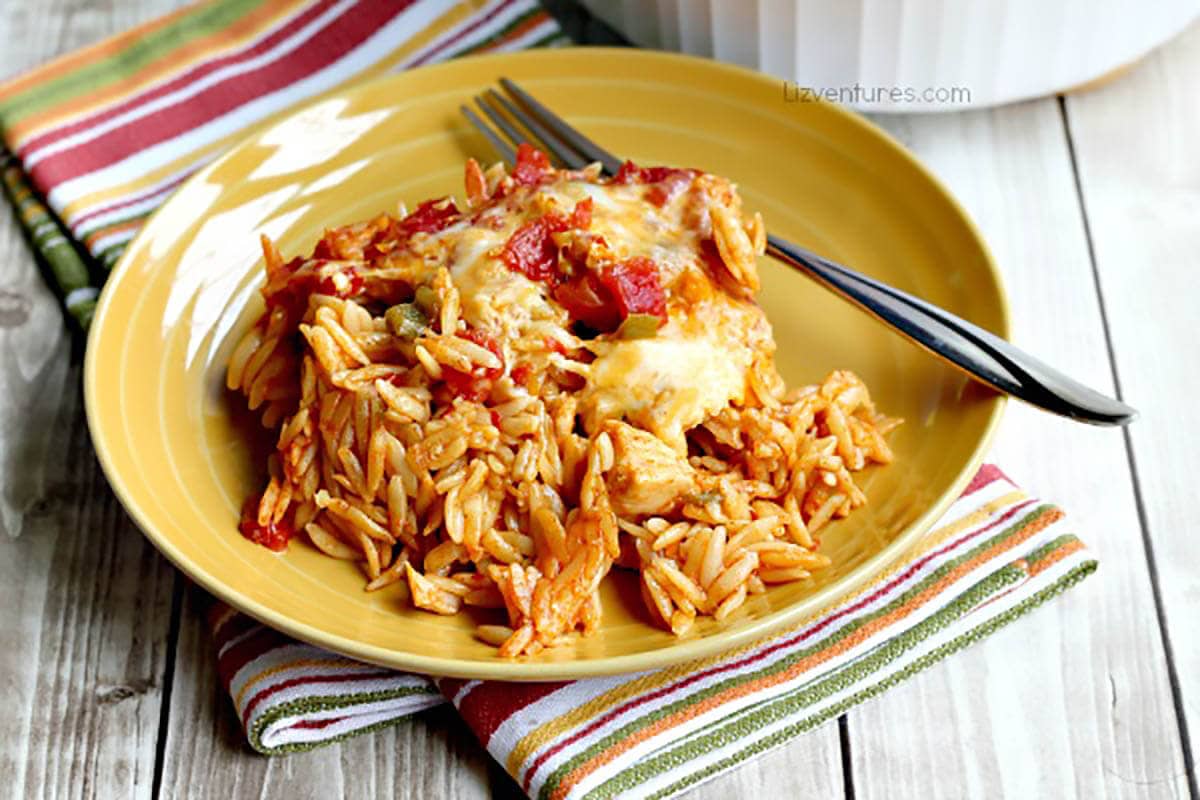Orzo chicken casserole on plate with fork.