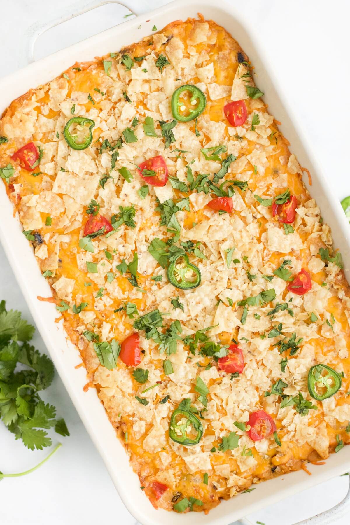 Chicken taco casserole in baking dish topped with chips.