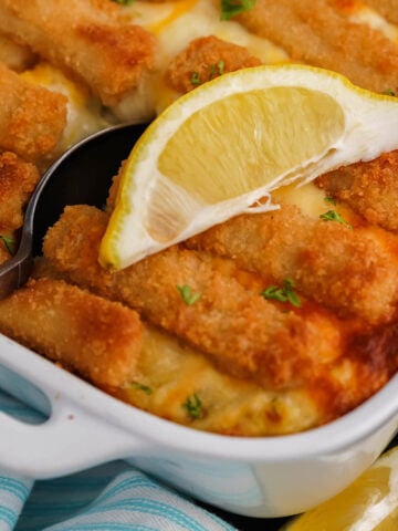 Fishstick casserole in baking dish with serving spoon.