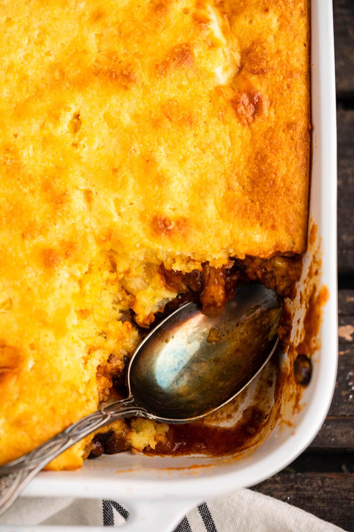 Tamale Pie in casserole dish with serving spoon.