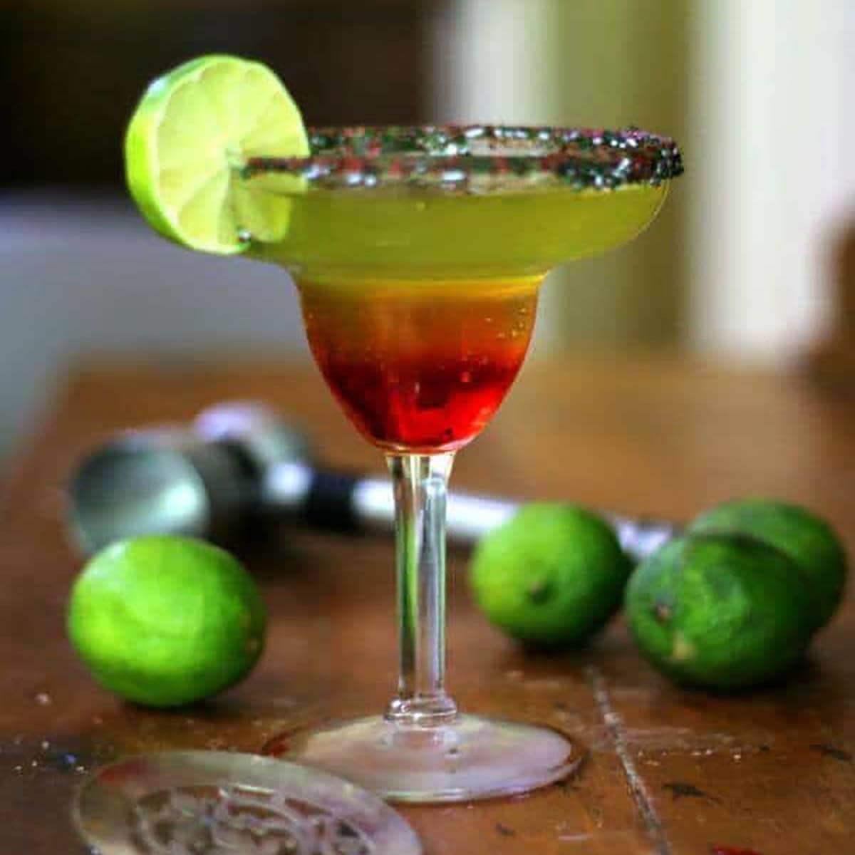 Dragons Blood Cocktail in margarita glass garnish with lime. 