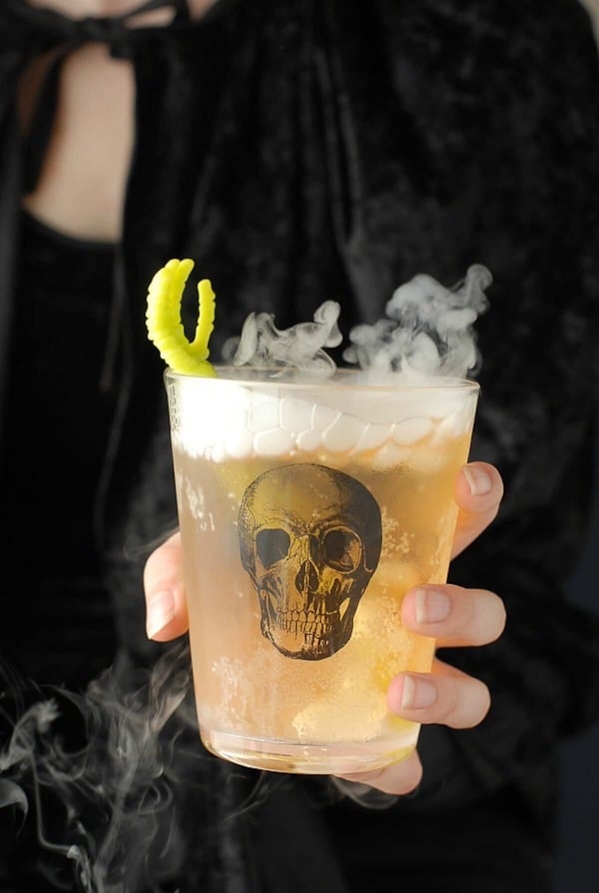 Scary cocktail in glass with halloween decor.