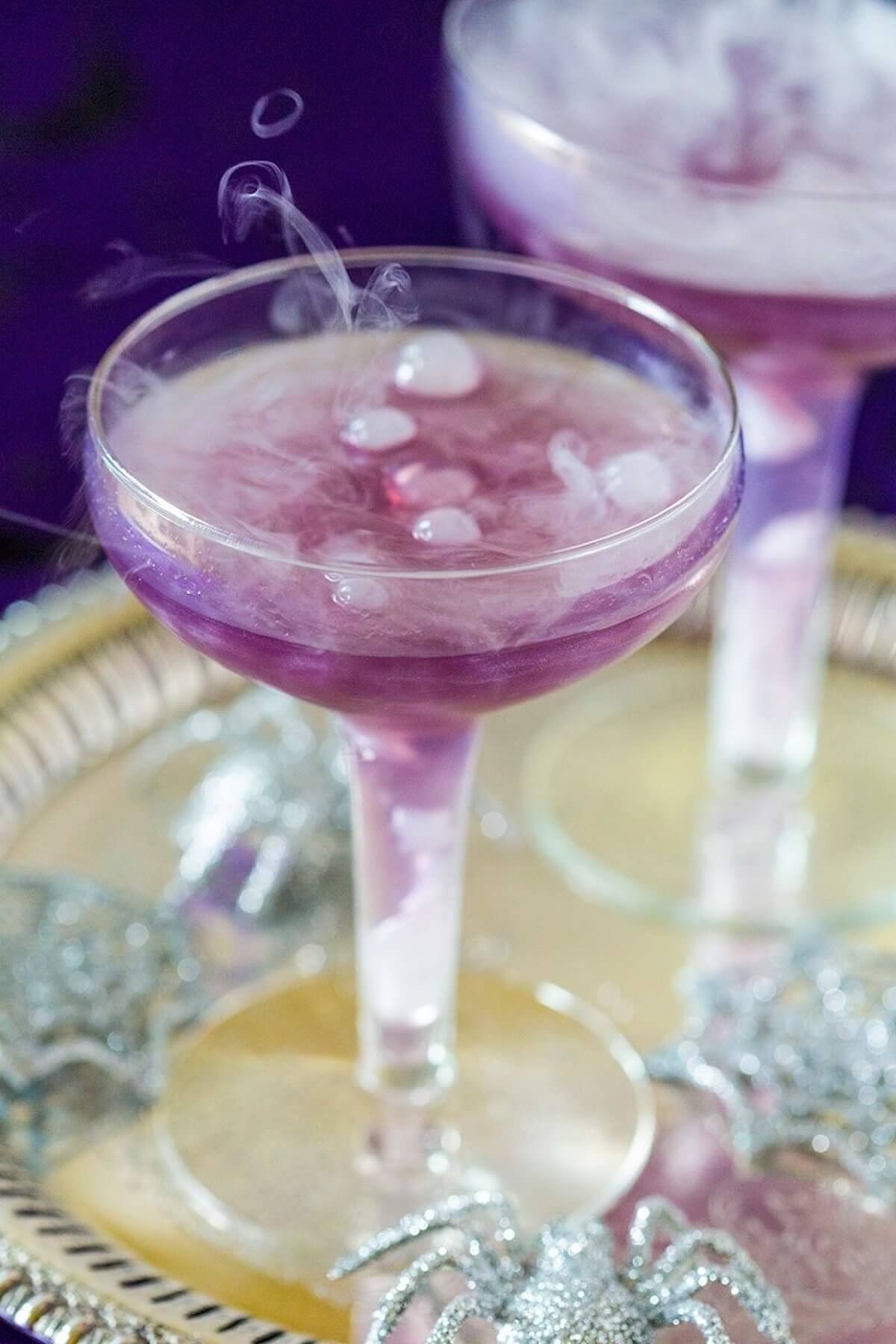 Sassy purple witches brew cocktails in martini glass.