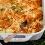 Chicken Cordon Bleu bake in casserole dish with serving spoon.