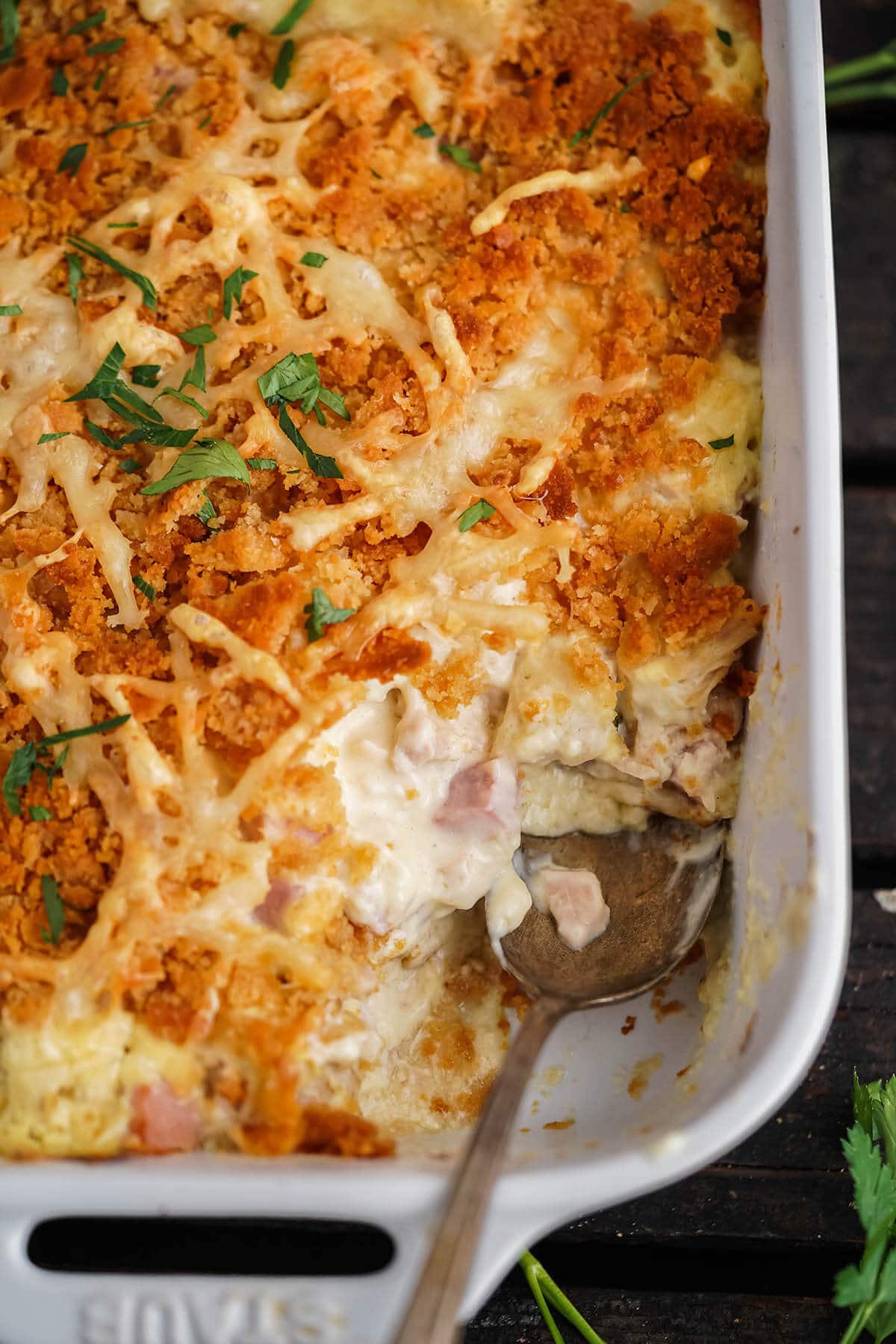 Cheesy Chicken Cordon Bleu Casserole in baking dish with serving spoon.