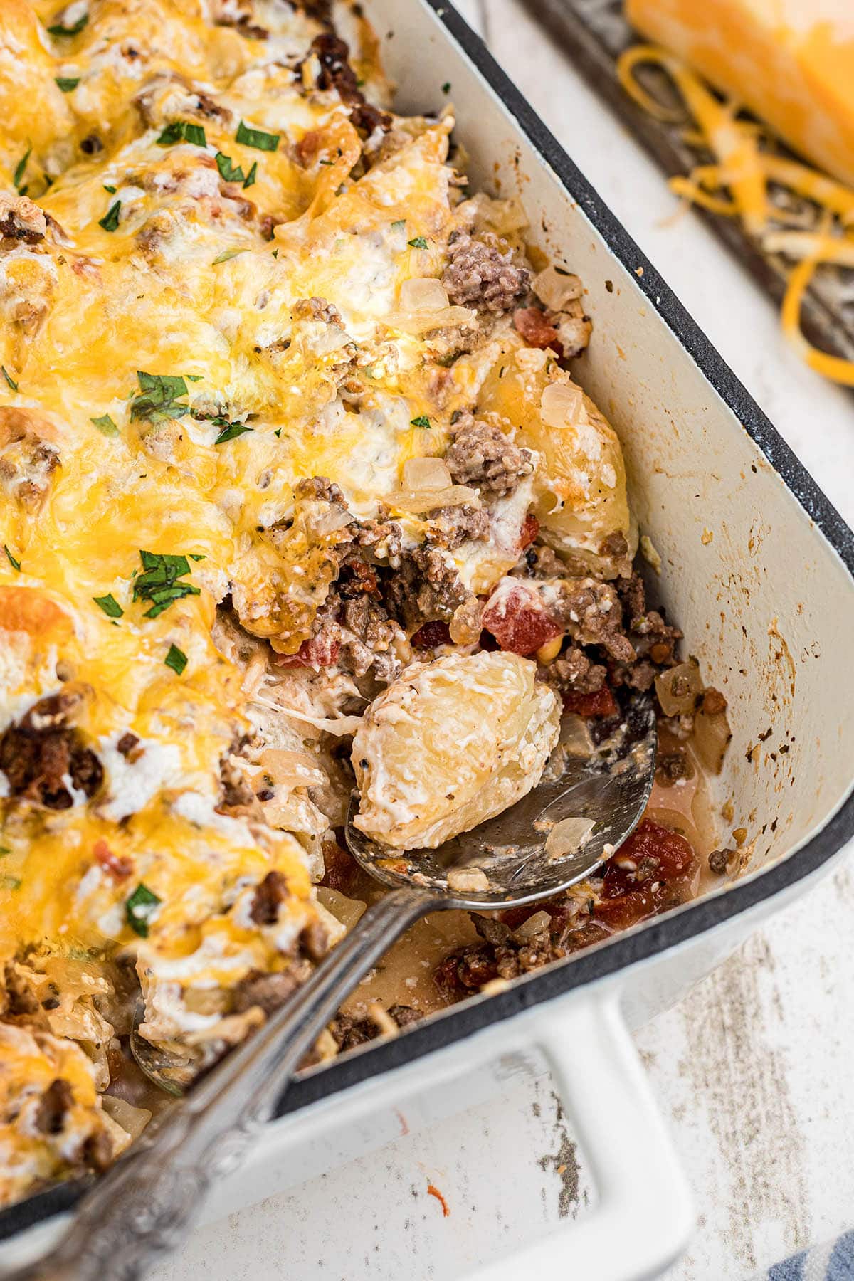 Meaty casserole in baking dish with serving spoon.