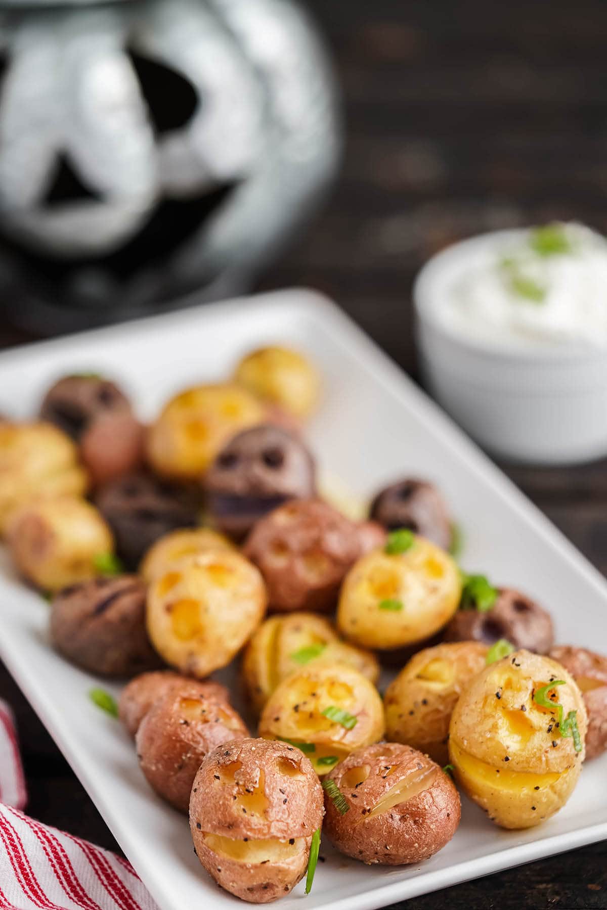 Halloween Potatoes on white platter with sour cream dipping sauce.