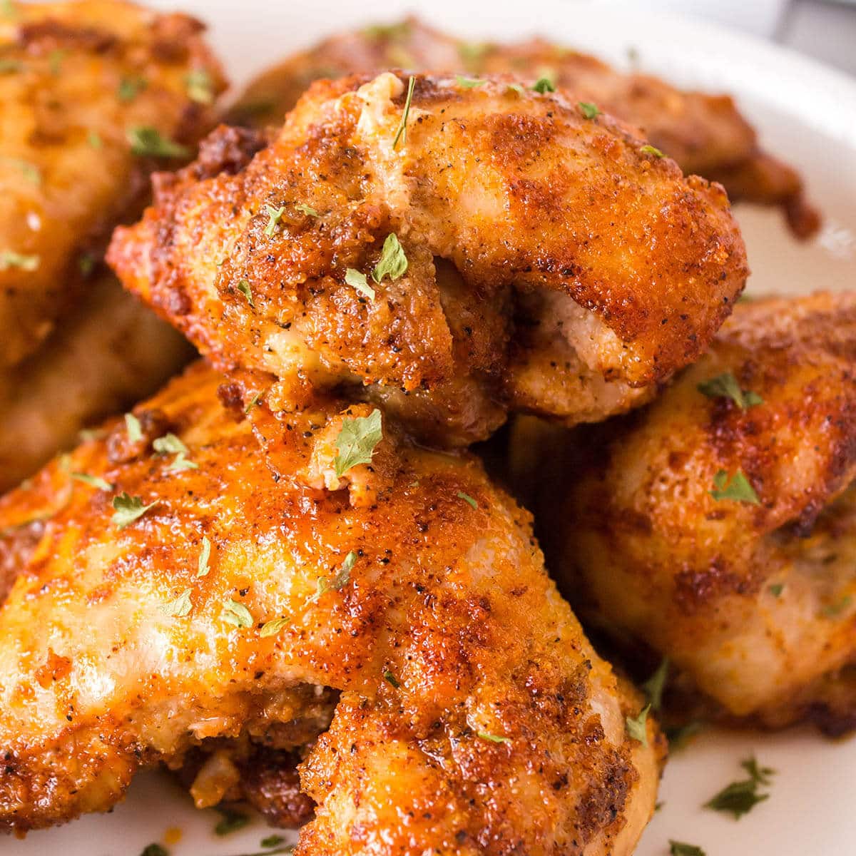Boneless chicken thighs cooked in air fryer on platter.