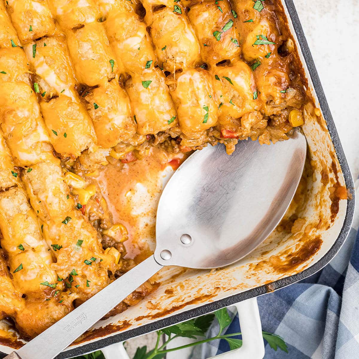 Cheesy Mexican Tater Tot Casserole in dish with spoon.