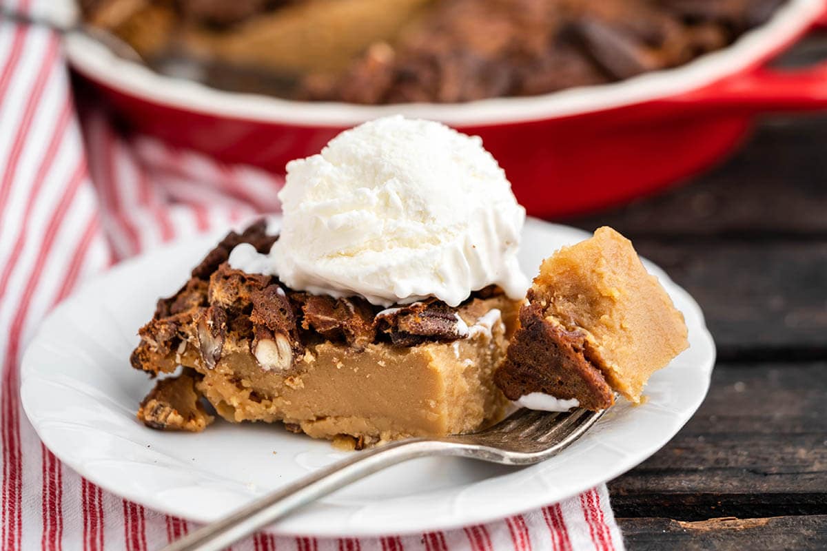 Slice of pie on plate with ice cream and fork.