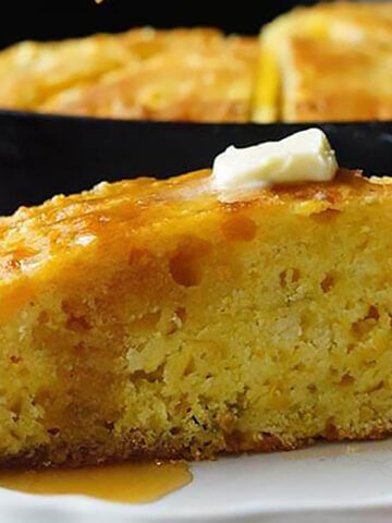 Jiffy Skillet Cornbread on plate topped with butter and honey.