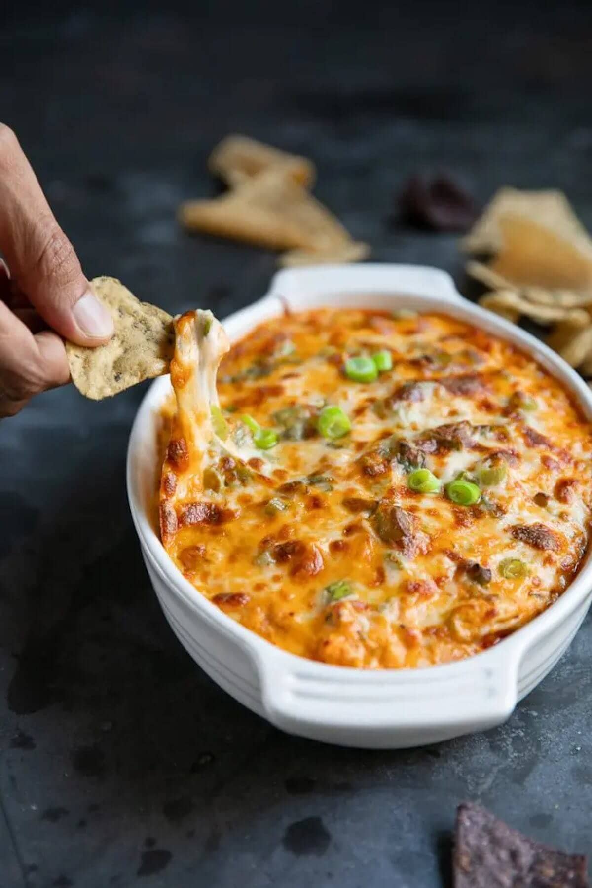 Cheesy buffalo chicken dip in casserole dish with chips.