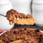 Slice of pecan pie in serving spatula, with pecan pie in background. With print overlay for Pinterest.