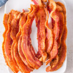 Drained crispy bacon on plate.