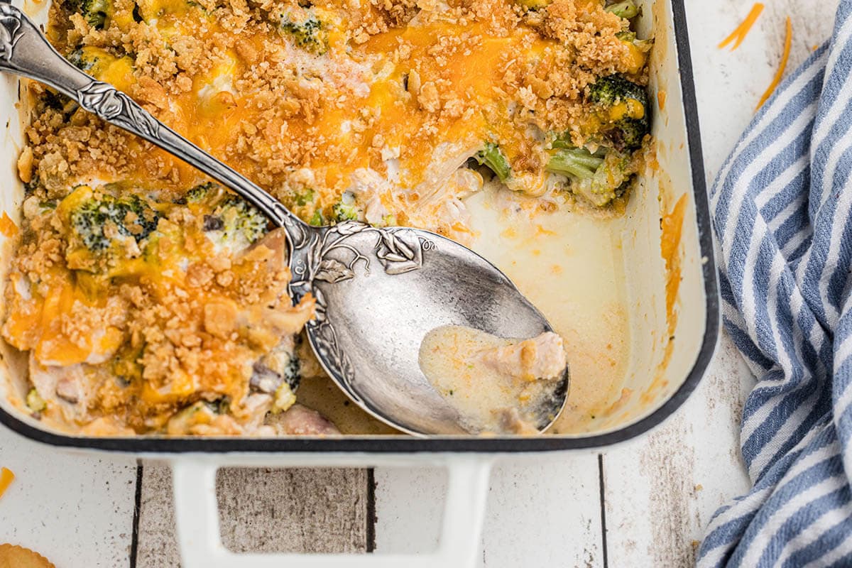 Chicken casserole with crispy topping in casserole dish with serving spoon.