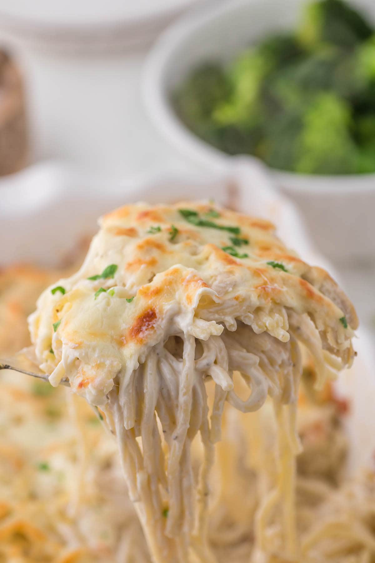 Million Dollar Chicken Casserole in baking dish with serving spoon.