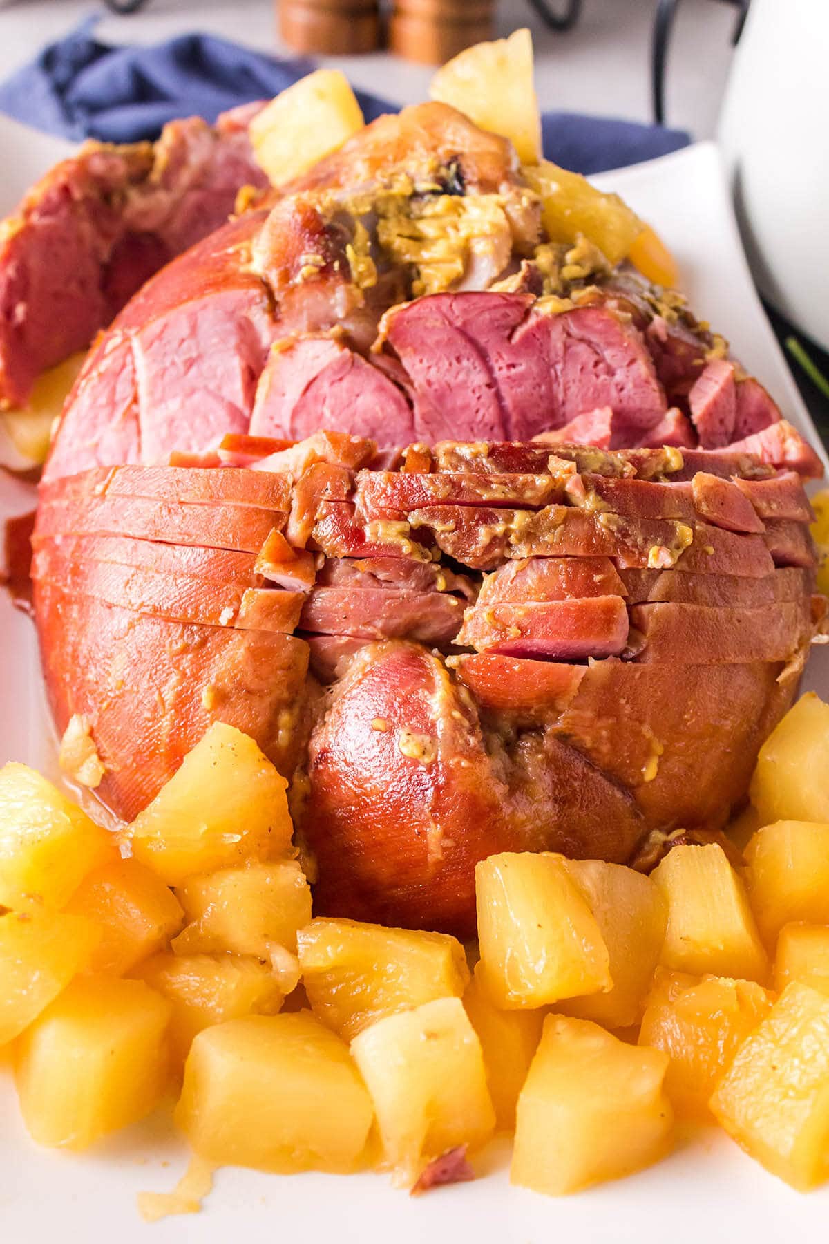 Cooked ham with pineapple on platter.