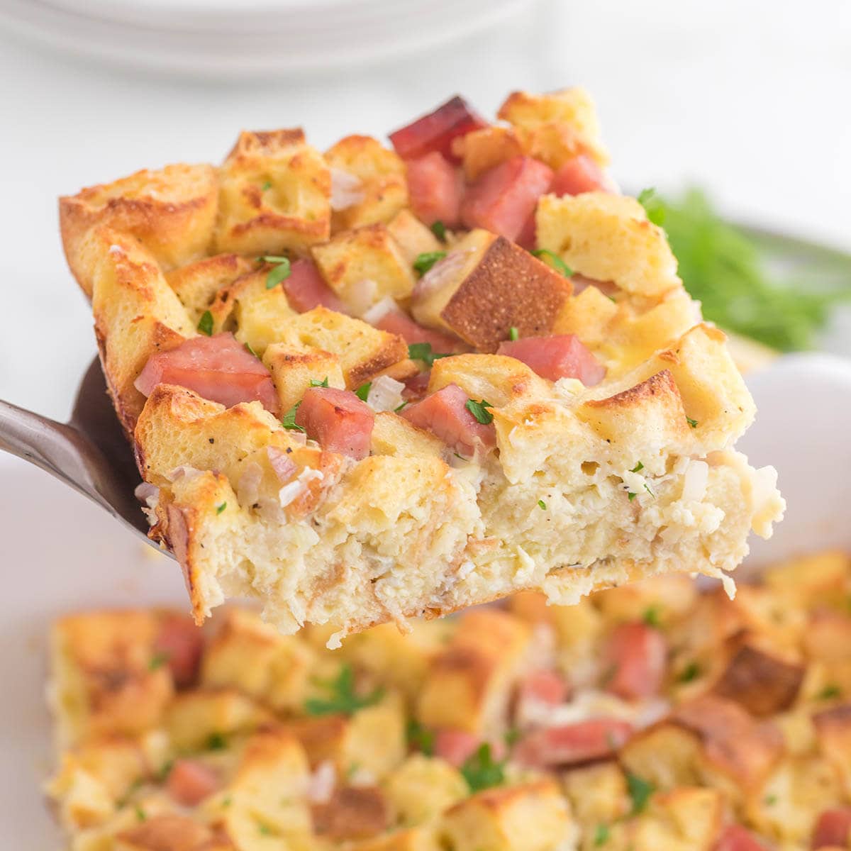 Eggs Benedict Casserole with serving spoon.