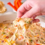 Cheesy dip in container with chip for dipping.